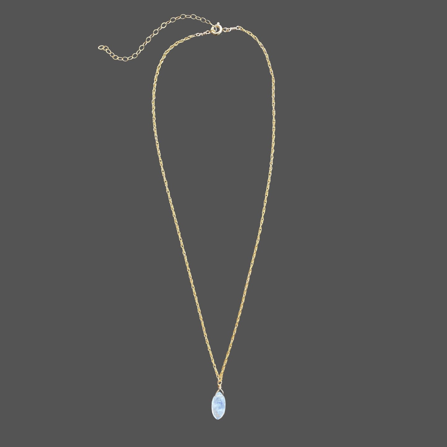 Gemstone pendant necklace with marquise shaped rainbow moonstone pendant centered on a delicate gold rope chain. Shown alone on plain background.