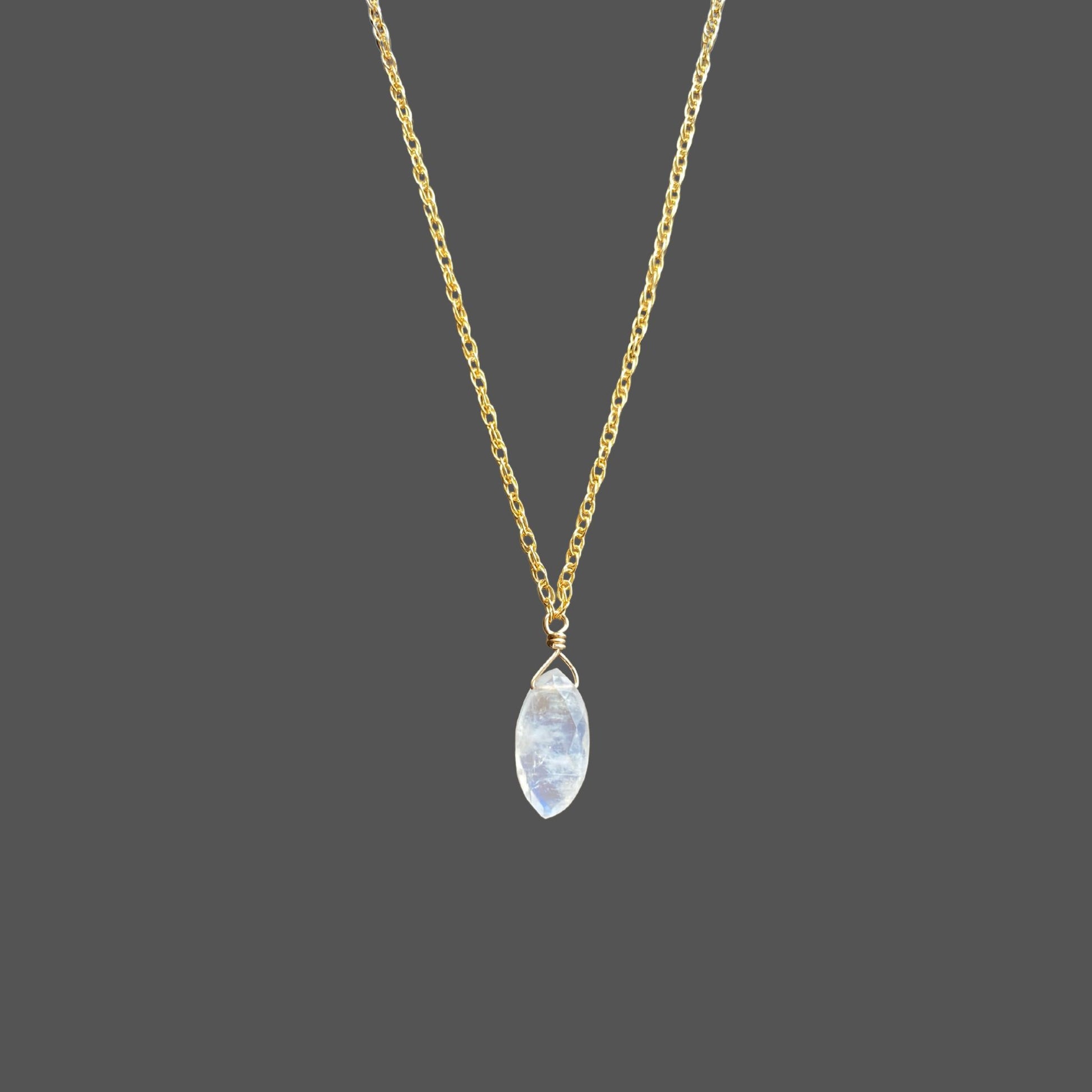 Close-up view of marquise shaped rainbow moonstone pendant on gemstone necklace with gold chain. Shown alone on plain background.