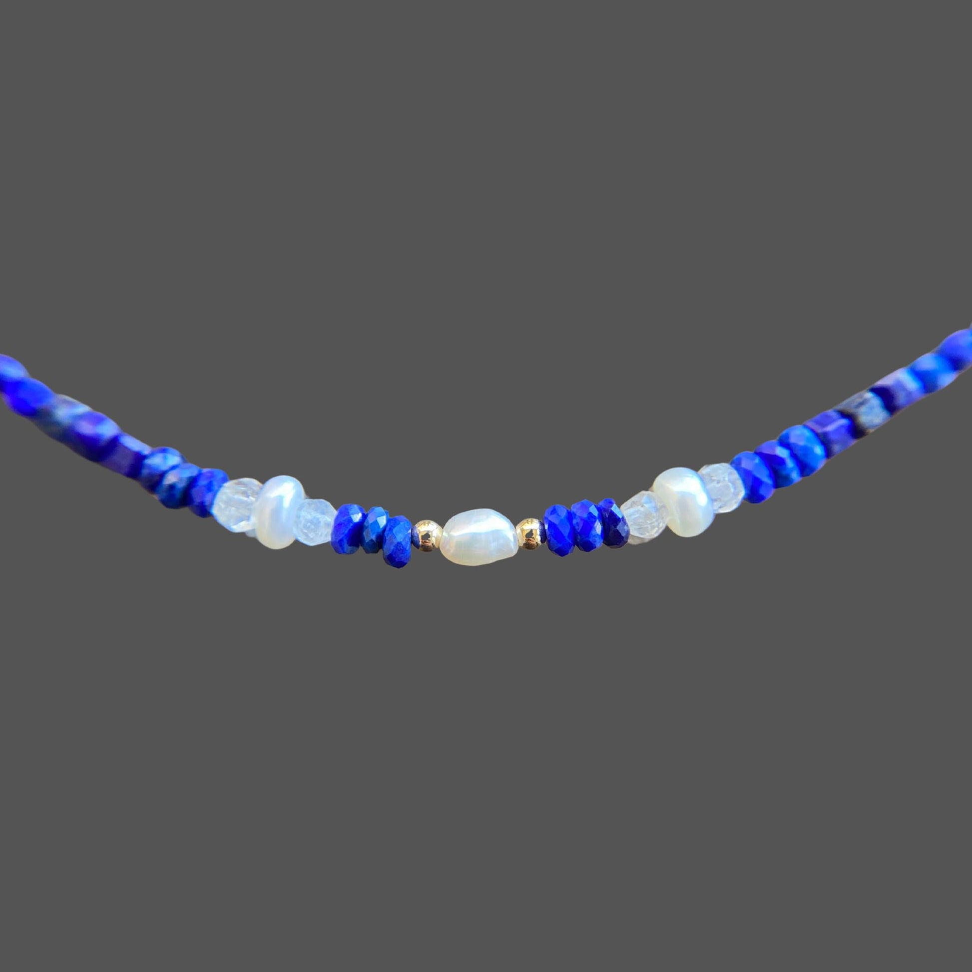 Close-up of centerpiece on gemstone necklace with pearls and moonstone.