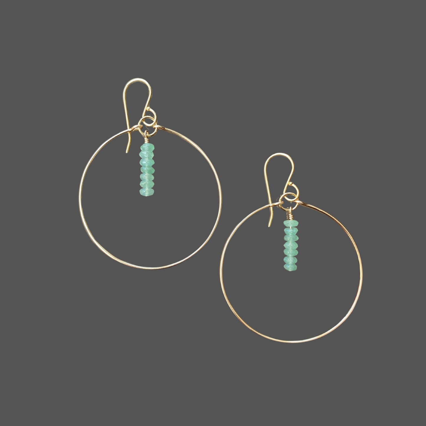 Gold hoop earrings with green aventurine beads hung from top center of hoop, on french earwires.