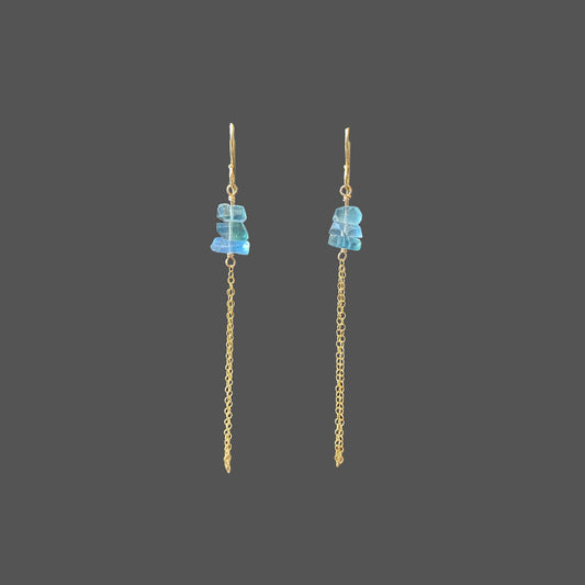 Front view of long earrings featuring three transparent blue-green fluorite stones, with delicate gold chains hanging below.