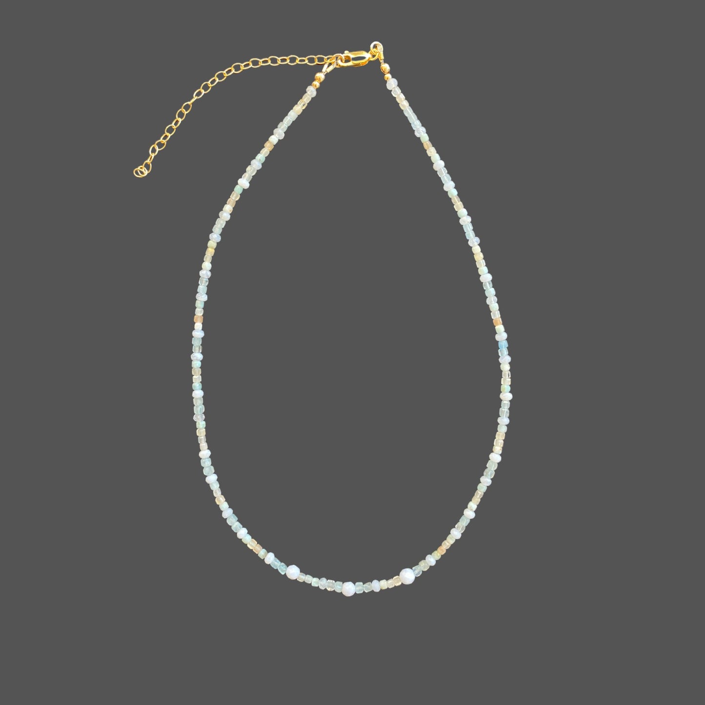 Minimalist beaded gemstone necklace featuring aquamarine, blue lace agate, larimar, and sunstone gems in soft blue hues.