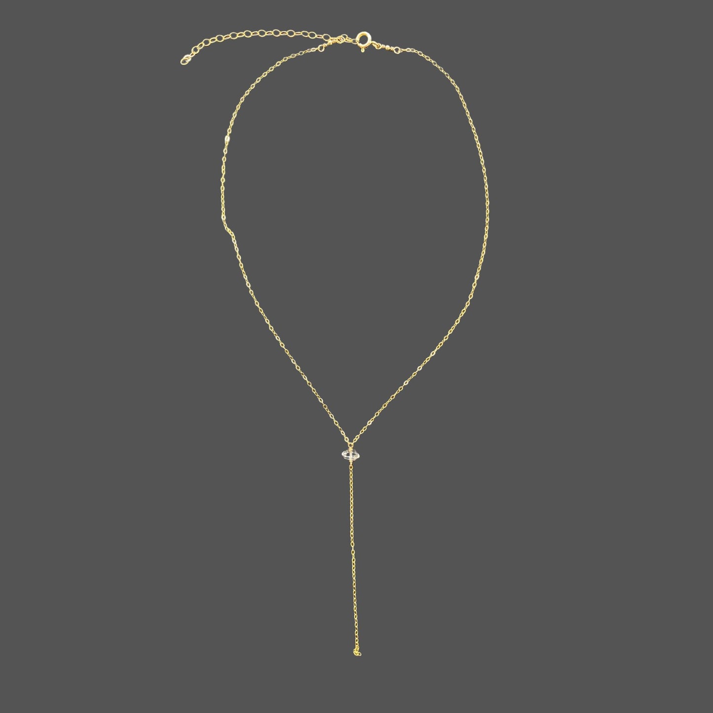 Gold chain necklace with herkimer diamond pendant and cascading strand of chain. Shown alone on plain background.