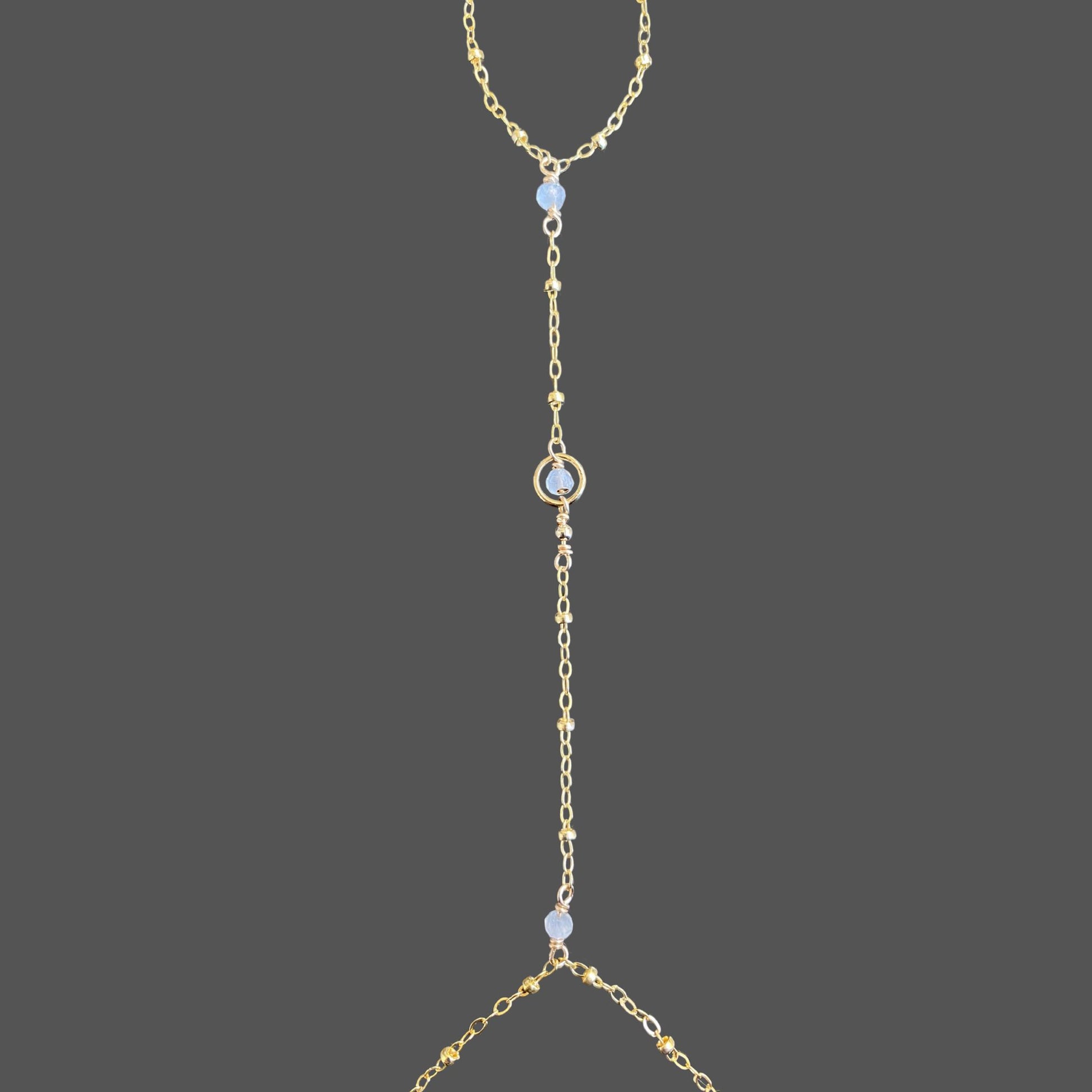 Close-up of moonstone hand chain, highlighting three moonstone beads and a gold-filled beaded chain.