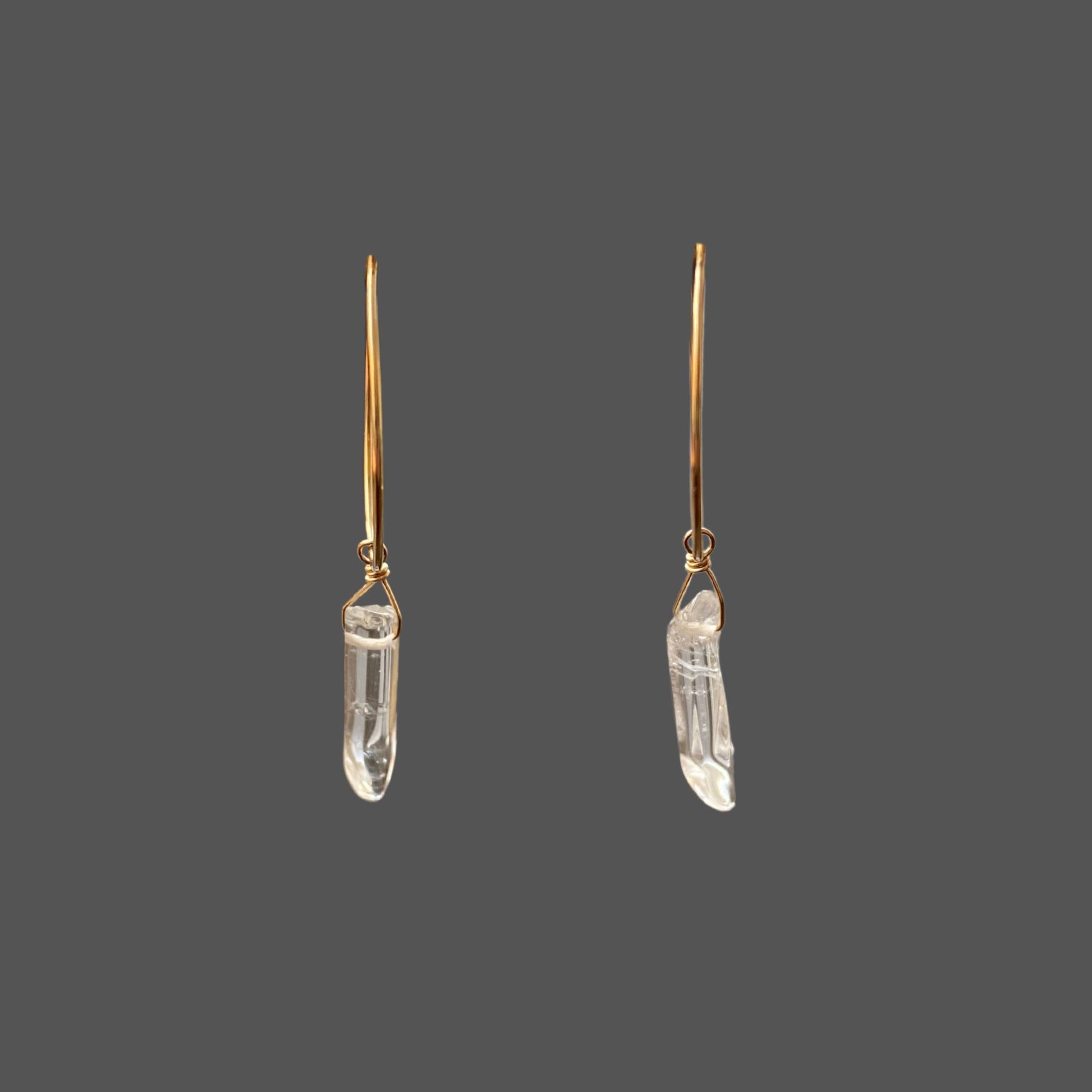 Gold hoop earrings with clear quartz points, shown against plain background.