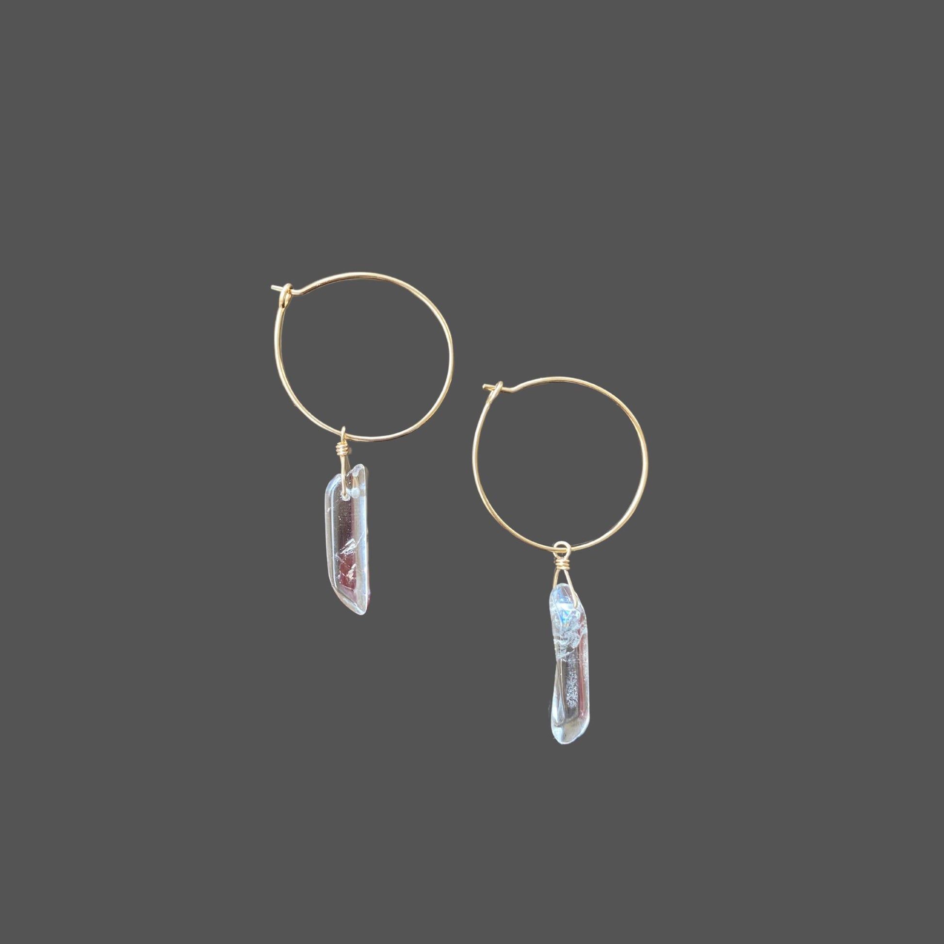 Side view of bohemian gold hoop earrings with clear quartz points.