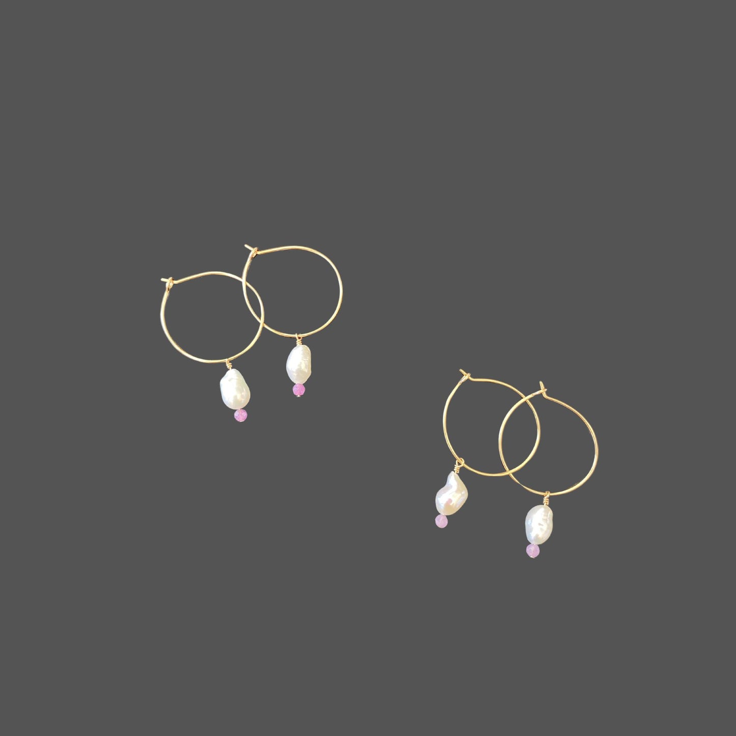 Two pairs of pearl earrings on gold hoops, each with a freshwater pearl and purple sapphire bead, showcasing a range of purple hues in the sapphires.