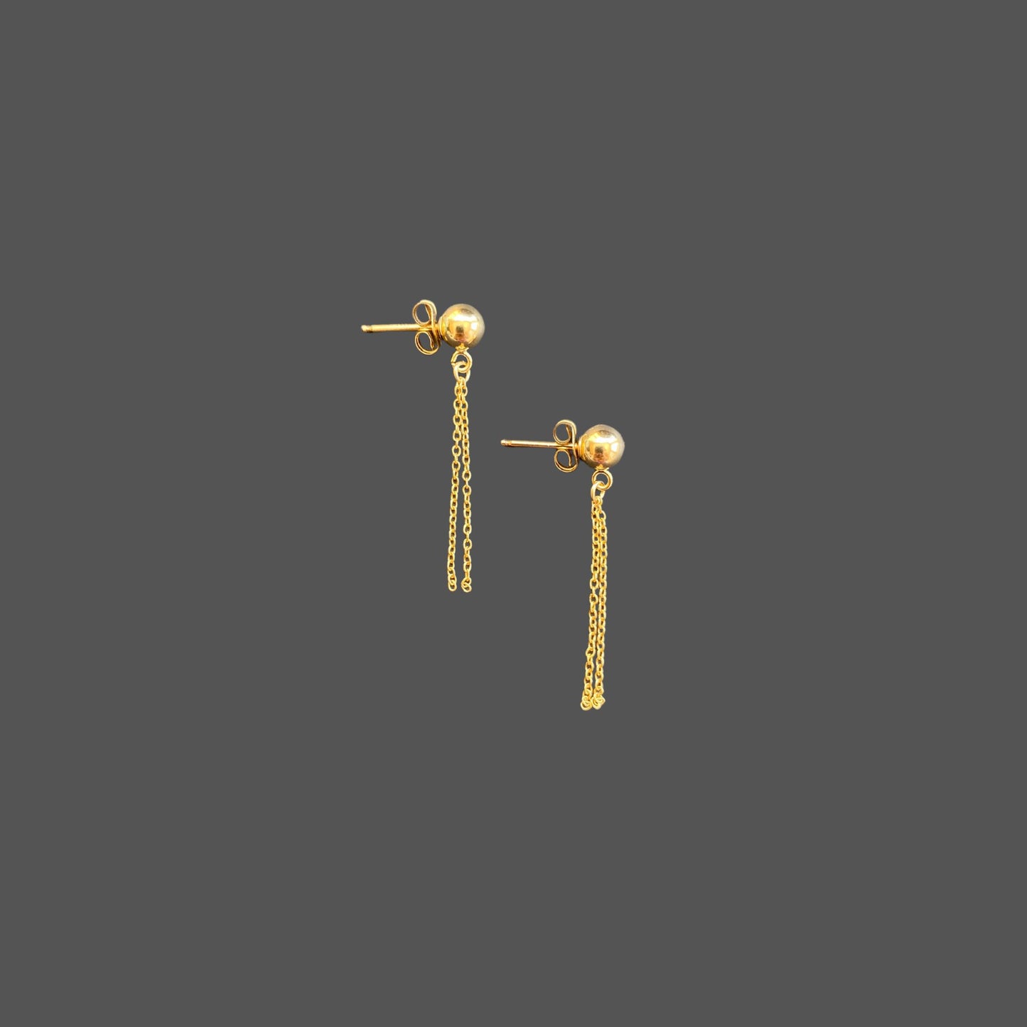 Side view of stud earrings with a gold ball stud and two strands of gold chain hanging below the ball.