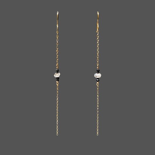 Long earrings shown alone on plain background. A single strand of gold chain with herkimer diamond and black tourmaline gems at midpoint of the chain.