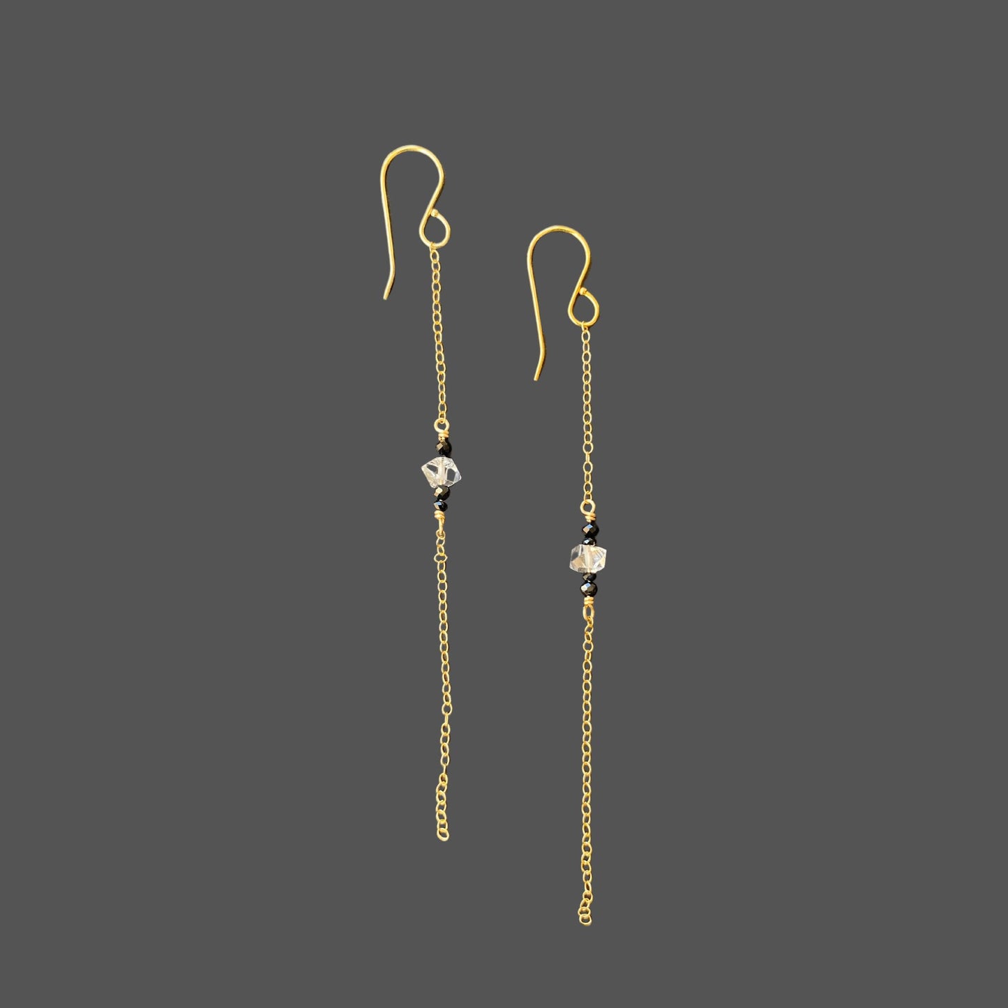 Side view of long earrings with a single strand of gold chain and gemstones at midpoint of the chain. Featuring herkimer diamond and black tourmaline.