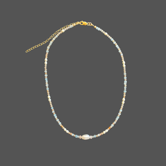 Beaded pearl necklace with freshwater pearls, and aquamarine and sunstone gems in the colors of sunset. Shown alone on plain background.